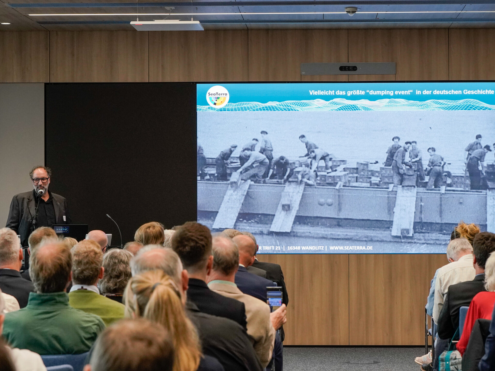 Nach dem Zweiten Weltkrieg wurden zehntausende Tonnen Munition direkt aus den Arsenalen und Munitionsfabriken in Nord- und Ostsee verklappt. Dieter Guldin von der Räumfirma Sea Terra präsentierte alarmierende Archivfotos auf der Veranstaltung in Kiel. Foto: Sarah Uphoff