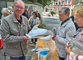 Nahezu jeder Gottesdienstbesucher wollte nach einem Obolus für die Spendenbüchse auch einen der frisch geräucherten Fische mit nachhause nehmen. Bild: Claus-Werner Jonas