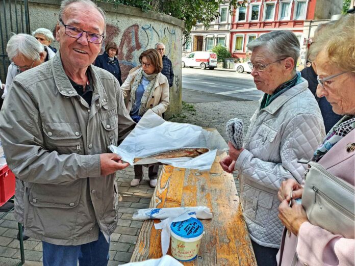 Nahezu jeder Gottesdienstbesucher wollte nach einem Obolus für die Spendenbüchse auch einen der frisch geräucherten Fische mit nachhause nehmen. Bild: Claus-Werner Jonas